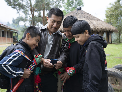 Grupo de jóvenes mirando la pantalla de un celular