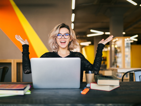 Mujer sonriendo mientras usa su computador